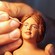 Una mano pintando el rostro de la figura de una mujer